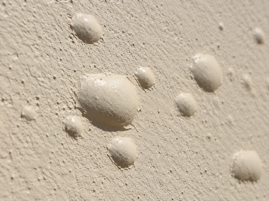 Bulles et boursouflures sous une peinture de façade